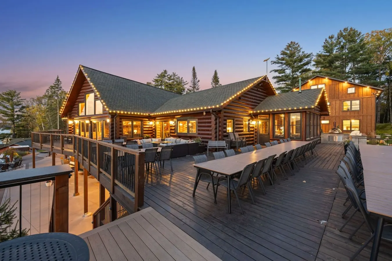Deck tables at dusk outside the lit lodge