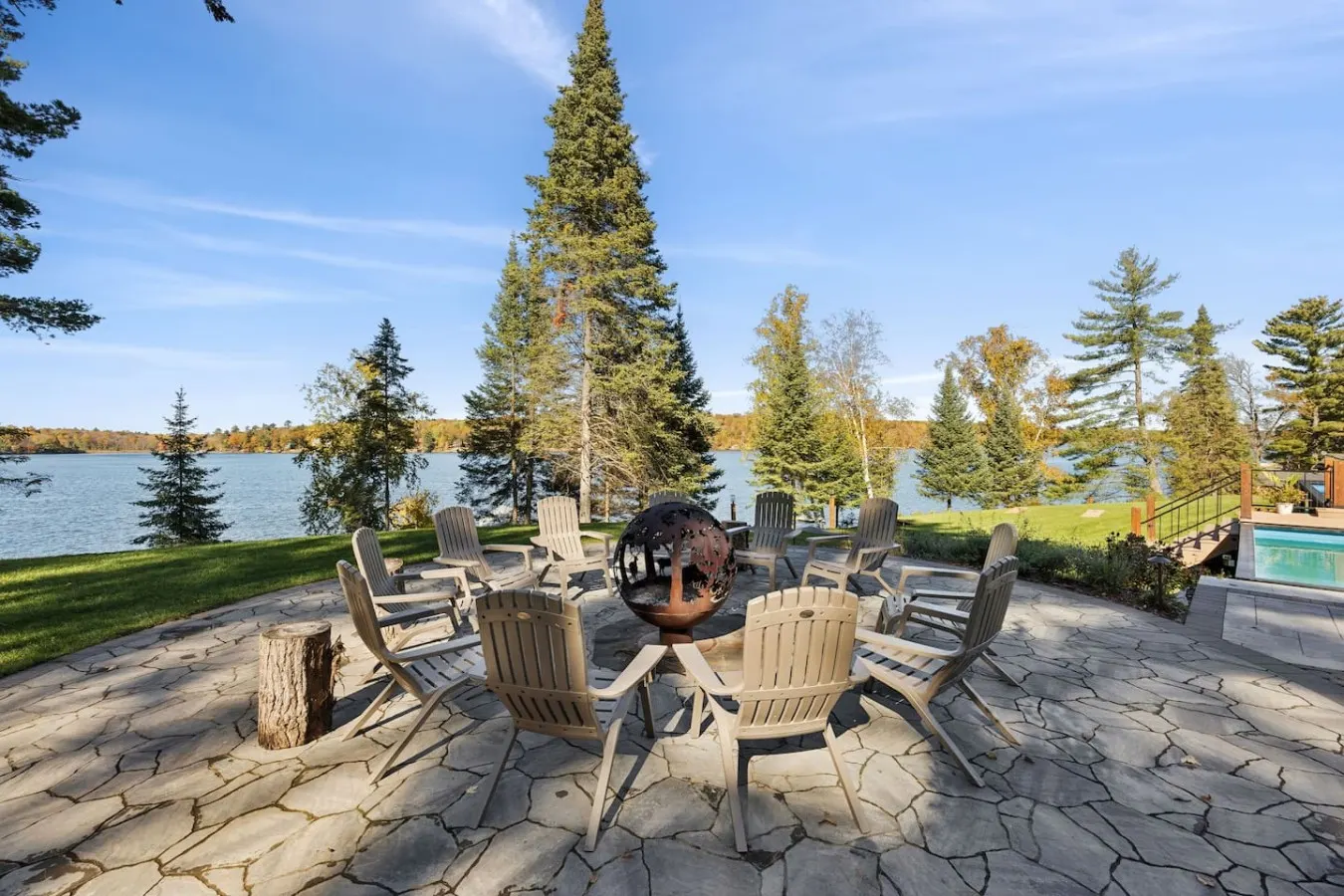 Fire pit with Adirondack chairs facing the lake